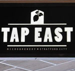 The pub sign. Tap East, Stratford, Greater London